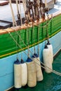 Buoys hanging outside the hull of a colorful wooden sailing boat