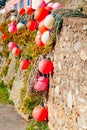 Buoys of nets and colorful moorings that dry against a wall in the sun, typical landscape of a fishing port Royalty Free Stock Photo
