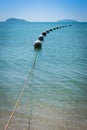 Buoys strung together on beautiful blue sparkling waters and clear sea Royalty Free Stock Photo