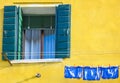 Burano island and village. The colored building yellow and the clothes are hanging to dry. Old houses and Venetian lagoon, Venice Royalty Free Stock Photo