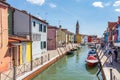 Burano, Italy with colorful painted houses along canal with boats