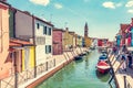 Burano, Italy with colorful painted houses along canal with boats