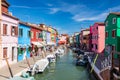 Burano, Italy with colorful painted houses along canal with boats