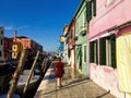 A young female tourist by herself exploring the beautiful view of the famous canals and colourful homes