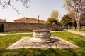 Burano old stone baroque well with a metal lid in the park, Venice, Venezia, Italy Royalty Free Stock Photo