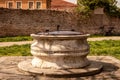 Burano old stone baroque well with a metal lid in the park, Venice, Venezia, Italy Royalty Free Stock Photo