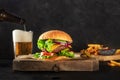 Burger and beer. Hamburger with beef, cheese, onion, tomato, and green salad Royalty Free Stock Photo