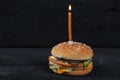 Burger with a candle with fire