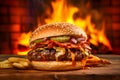Burger with cheese, sauce, bacon, onion and cucumber on a wooden board, fire in the background