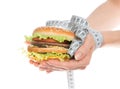 Burger cheeseburger in hands with measure tape Royalty Free Stock Photo