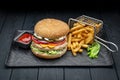 Burger with chicken cutlet and french fries on a dark background Royalty Free Stock Photo