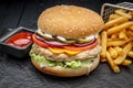 Burger with chicken cutlet and french fries on a dark background Royalty Free Stock Photo