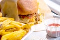 burger and chips close up. Unhealthy food in the pub. Delicious burgers with beef, tomato, cheese and french fries. Royalty Free Stock Photo