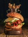 Burger with chopped meat, egg and arugula on a wooden table Royalty Free Stock Photo