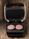 Burger cutlets are fried on a smart electric grill, homemade burgers