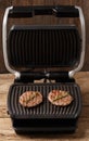 Burger cutlets are fried on a smart electric grill, homemade burgers