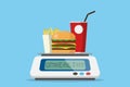 Burger with drinks and french fries on digital weight scale with healthy word, diet and health concept Royalty Free Stock Photo