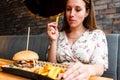 Burger eating woman. Pretty Young Happy Girl Eat Tasty Hamburger. Junk Food Concept. Royalty Free Stock Photo