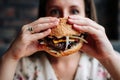 Burger eating woman. Pretty Young Happy Girl Eat Tasty Hamburger. Junk Food Concept. Royalty Free Stock Photo