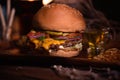 Burger food photo. Street food. Fresh tasty grilled beef hamburger cooked at barbecue on wooden table. Big cheeseburger