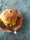 burger food stuffed with meat, cheese, onions, tomatoes, salad with a beachside cafe background Royalty Free Stock Photo