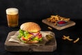 Burger with French fries and beer. Hamburger with beef, cheese, onion, tomato etc Royalty Free Stock Photo