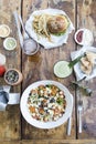 Burger with french fries and cheese salad, lettuce, tomato, olives, onion and cheese, with beer and fruit juice, on a wooden table Royalty Free Stock Photo