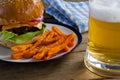 Burger and french fries in plate with glass of beer Royalty Free Stock Photo