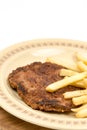 Burger with french fries served on the plate. Minced meat hamburger with potatoes isolated over white background Royalty Free Stock Photo