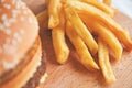 Burger and French fries on a wooden Board