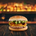 Burger with fried patato and cheese at wooden tabletop with blurred bar at backdrop . Fastfood advertising concept