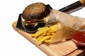 Burger with fries on a wooden board on white background Royalty Free Stock Photo