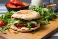 burger with grilled halloumi cheese, rocket salad and sun-dried tomatoes