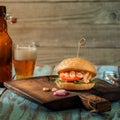 Burger with grilled shrimp on wooden table with lager Royalty Free Stock Photo