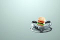 Burger in a large metal bear trap, close-up. The concept of gluttony, obesity, fast food, addiction, malnutrition. 3D render, 3D