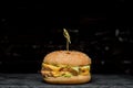 Burger with a latch on a wooden board on a black background