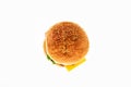 Burger of light bun with sesame, with greens, cheese, ketchup and meat cooked at home on white plate. White isolated background.