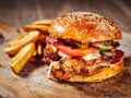 burger with pork ribs, spicy sauce and fresh vegetables on wooden cutting board Royalty Free Stock Photo