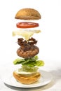 Burger preparation sliced  ingredients levitating on white background Royalty Free Stock Photo