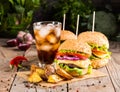 Burgers with beef and fried potatoes and glass of cold beer