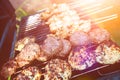 Burgers and chicken kebabs on hot barbecue outdoor in the evening sun. Royalty Free Stock Photo