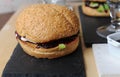 Burgers closeup. Beer, berry sauce on a slate boards. Wooden textural background