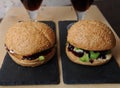 Burgers closeup. Beer, berry sauce on a slate boards. Wooden textural background