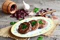 Burgers made from boiled and mashed red beans on a plate. Scattered uncooked red beans, garlic, fresh parsley, small spoon