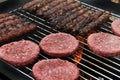 Burgers and meat on skewers on home barbeque. Royalty Free Stock Photo