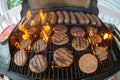 Burgers and sausages cooking on grill