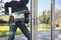 Burglar breaking into a house via a window with a crowbar Royalty Free Stock Photo