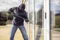 Burglar breaking into a house via a window with a crowbar