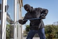 Burglar breaking into a house via a window with a crowbar Royalty Free Stock Photo