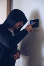 A burglar breaks into a house. He is trying to disarm the alarm system. Royalty Free Stock Photo